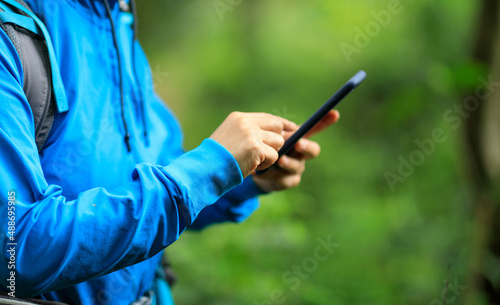 Woman hiker using smartphone  in spring forest