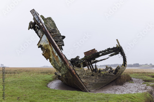 A cloeup shot of ruined, abandoned boats on the banks of the river photo