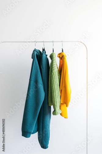 Bright colorful collection of clothes on a rack. Fashion concept