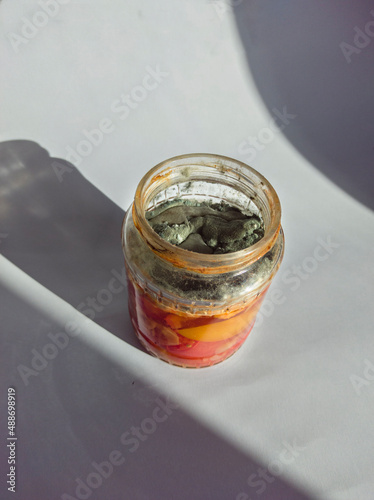 Gray and green mold in a jar with canned tomatoes.Mold on old food.