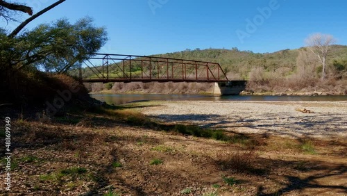 Walking toward a metal bridge over Mokelumne River in amador county California photo