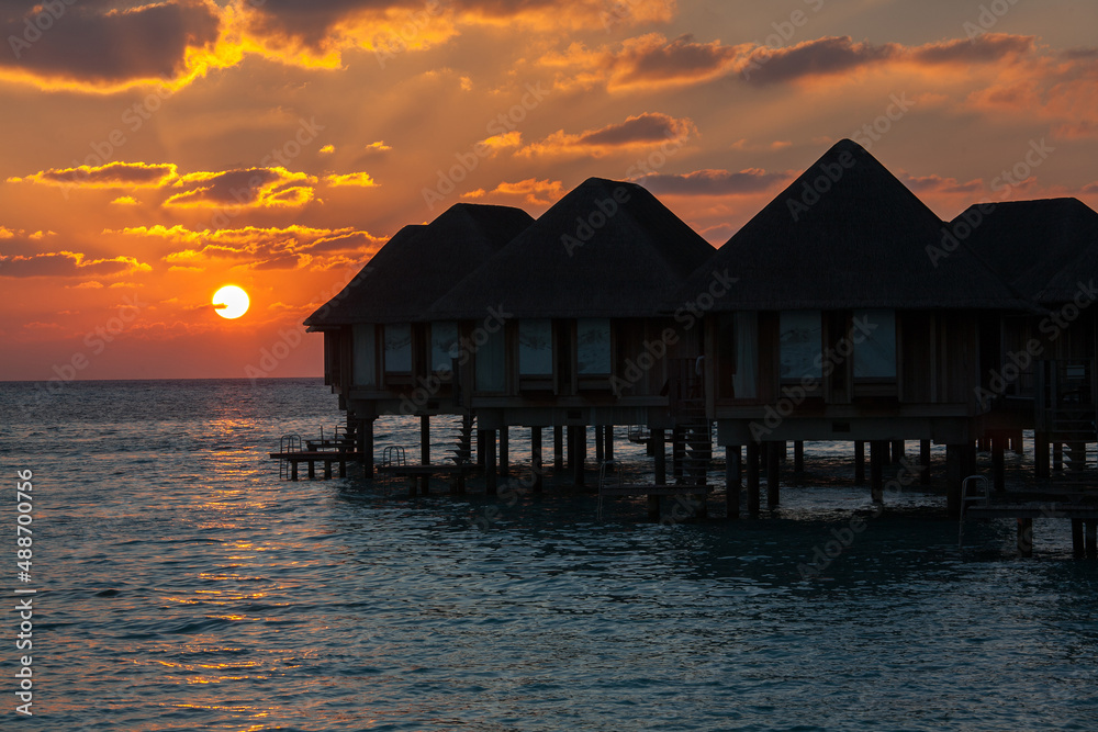 Sunset over Water Bungalows in Turquoise Sea at Maldives