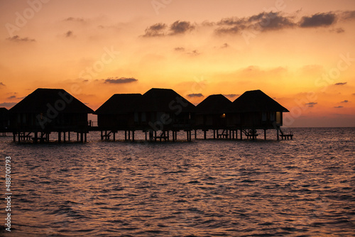 Sunset over Water Bungalows in Turquoise Sea at Maldives