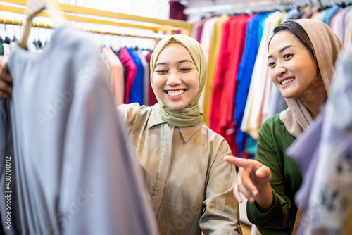 muslim female friend buying new dress at fashion store