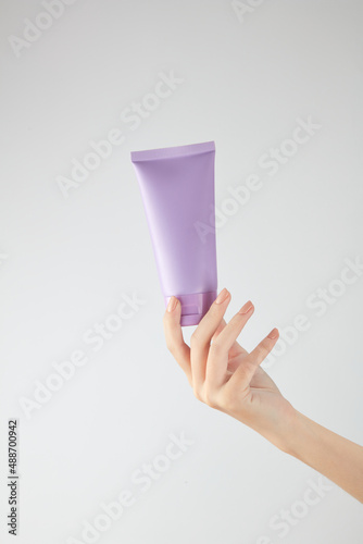 Hand model holding a cosmetic jar with a white background for cosmetic advertising