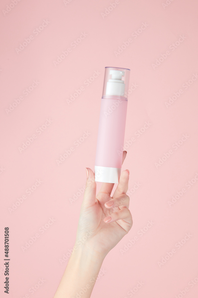 Hand model holding a cosmetic jar with a pink background for cosmetic advertising Hand model holding a cosmetic jar with a pink background for cosmetic advertising