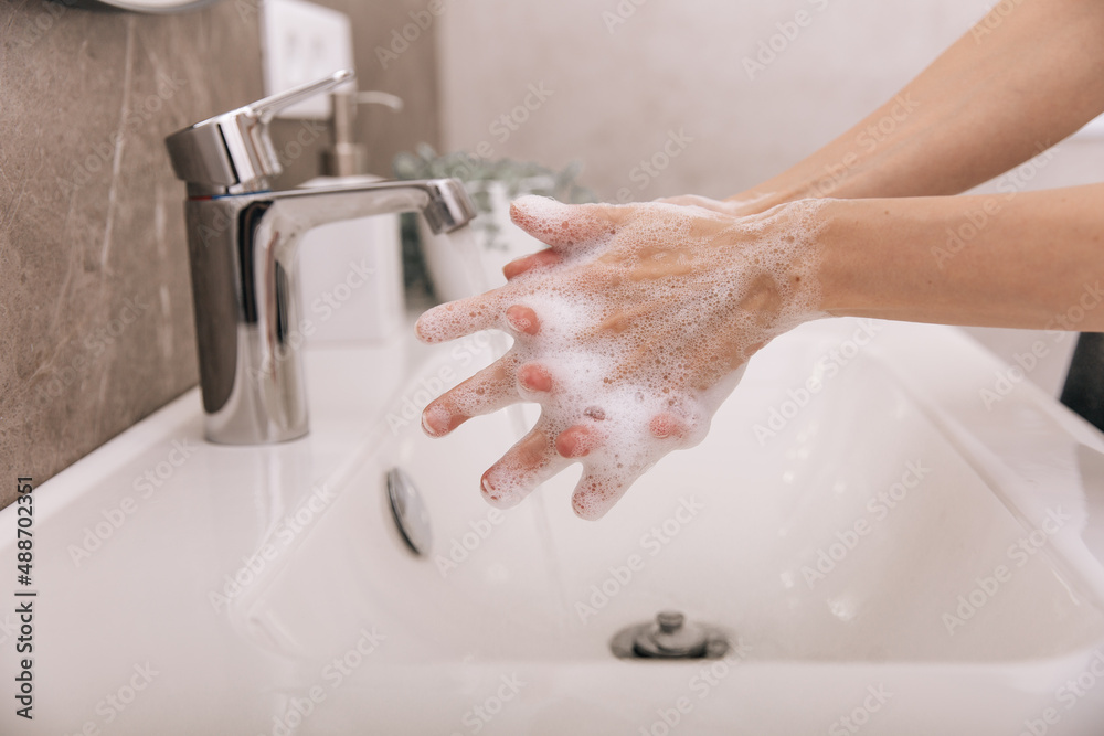 Washing hands under the flowing water tap. Washing hands rubbing with soap for corona virus prevention, hygiene to stop spreading corona virus in or public wash room. Hygiene concept hand detail Washing hands under the flowing water tap. Washing hands rubbing with soap for corona virus prevention, hygiene to stop spreading corona virus in or public wash room. Hygiene concept hand detail
