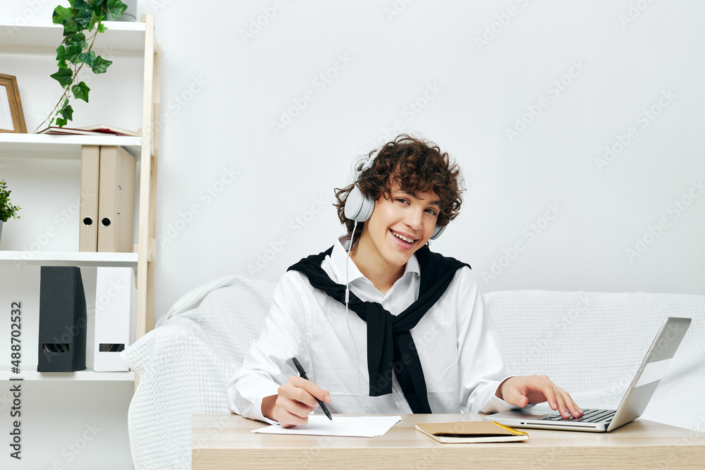 teenager laptop in headphones on white sofa Lifestyle technology teenager laptop in headphones on white sofa Lifestyle technology