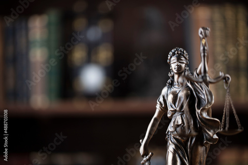 Judge office. Justice symbol - Themis sculpture on brown background.