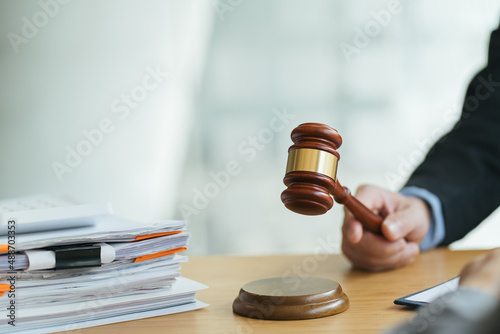 justice and law concept.Male judge in a courtroom on wooden table and Counselor or Male lawyer working in office. Legal law, advice and justice concept. photo