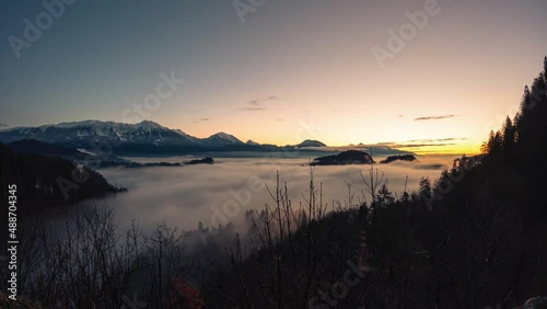 Bled Slovenia captured at sunrise with in the nature with beautiful mountains and landscapes cover in fog and nice golden hour colors filmed in a timelaps photo