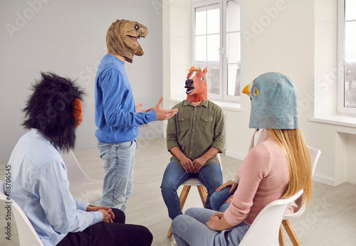 People wearing funny masks having a conversation during a group therapy session. Different male and female patients with animal faces talking, sharing their problems, and looking for solutions photo
