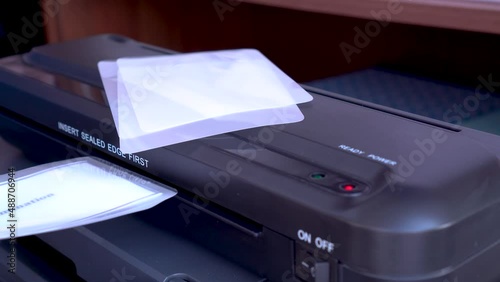 The Work Of The Laminator. close-up, selective focus. device for applying a transparent film to documents, photos, which reliably protects them from dust, moisture and other external influences.
