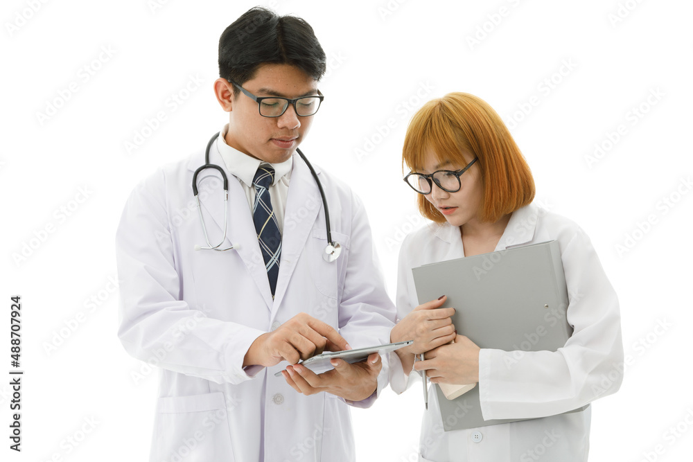 Isolated cutout studio shot of Asian young professional male doctor in lab coat with stethoscope and eyeglasses standing holding tablet discussing patient data with female intern on white background Isolated cutout studio shot of Asian young professional male doctor in lab coat with stethoscope and eyeglasses standing holding tablet discussing patient data with female intern on white background