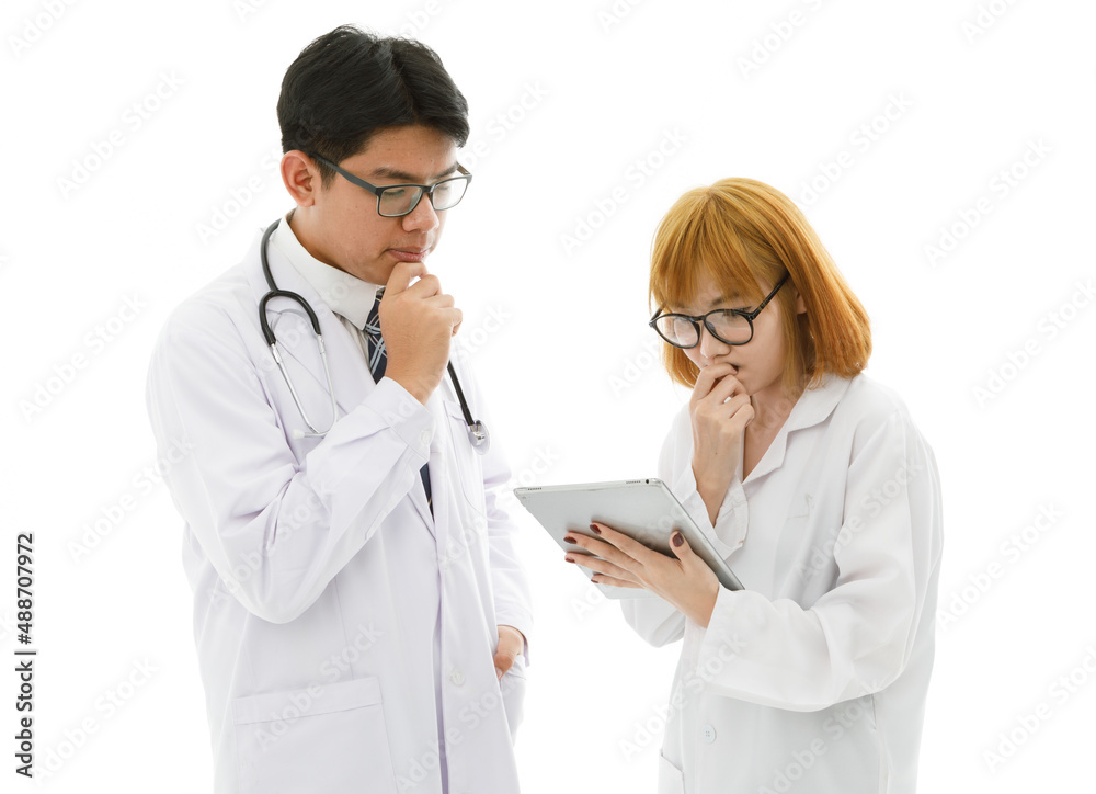 Isolated cutout studio shot of Asian young professional male doctor in lab coat with stethoscope and eyeglasses standing holding tablet discussing patient data with female intern on white background Isolated cutout studio shot of Asian young professional male doctor in lab coat with stethoscope and eyeglasses standing holding tablet discussing patient data with female intern on white background