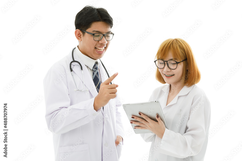 Isolated cutout studio shot of Asian young professional male doctor in lab coat with stethoscope and eyeglasses standing holding tablet discussing patient data with female intern on white background Isolated cutout studio shot of Asian young professional male doctor in lab coat with stethoscope and eyeglasses standing holding tablet discussing patient data with female intern on white background