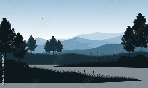 The beautiful mountain view in the morning from the riverside with silhouettes of pine trees around