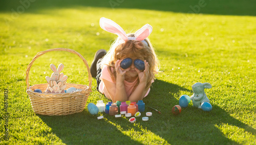 Happy easter bunny child boy cover eyes with eggs. Spring kids holidays concept.