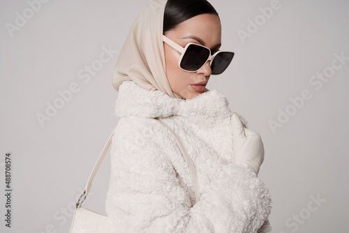 Beautiful young lady in a white faux fur coat photo
