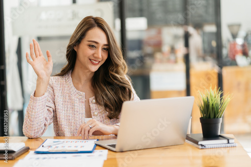 business woman talking about sale report in video conference. Asian team using laptop and tablet online meeting in video call.Working from home, Working remotely and Social isolation.