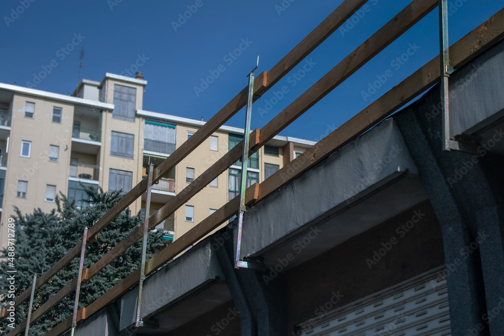Railing for building site facade: on the edge of the roof hooked to the roof cornice of the building under construction. Railing for building site facade: on the edge of the roof hooked to the roof cornice of the building under construction.