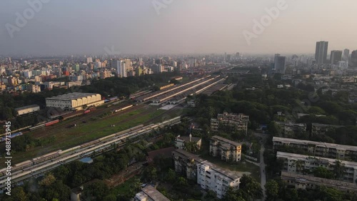 Aerial pull back reveal of Railway station with trainline in a city on hazy morning photo