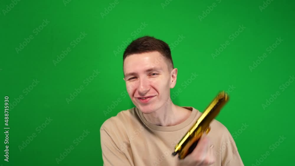 A man merrily shoots a pistol in all directions, a golden pistol, shooting on chromakey, green background A man merrily shoots a pistol in all directions, a golden pistol, shooting on chromakey, green background