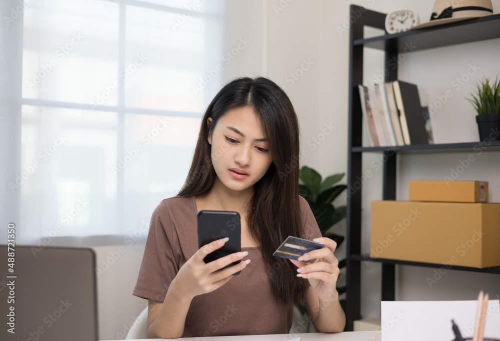 Stressed young asian woman holding smartphone and credit card in put the payment but Not enough money on credit card to pay Stressed young asian woman holding smartphone and credit card in put the payment but Not enough money on credit card to pay