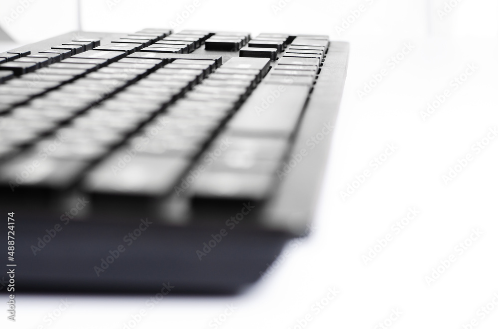 Computer keyboard on a white background. Closeup. Selective focus. Side view Computer keyboard on a white background. Closeup. Selective focus. Side view