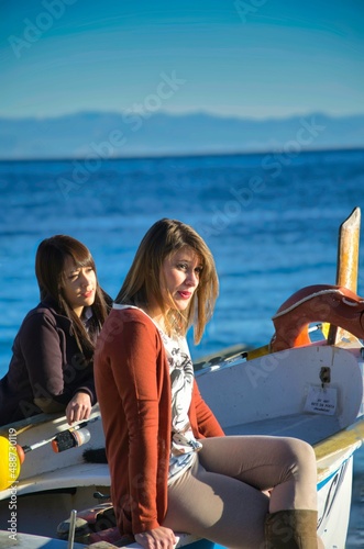 two models (a blonde and a brunette) pose for a photo shoot, on the coasts of the western Ligurian Riviera