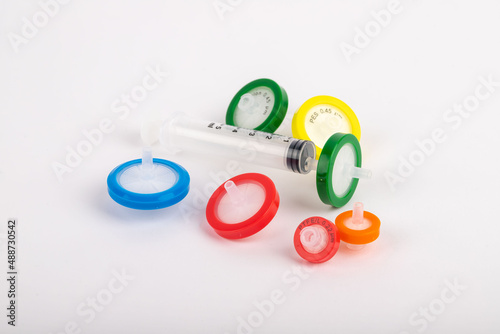Colorful needlepoint filters standing on a white background. They are used in experiments in a laboratory environment.