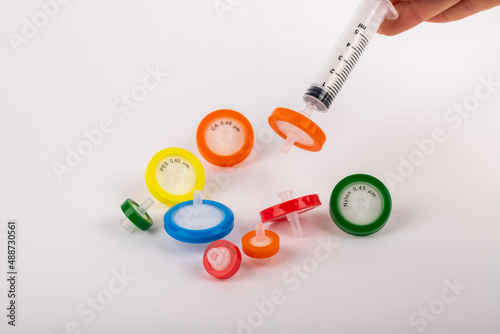 Colorful needlepoint filters standing on a white background. They are used in experiments in a laboratory environment.