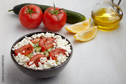 Bowl of chopped tomatoes and cucumbers with cottage cheese