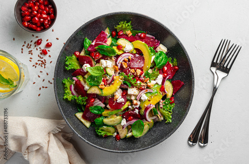 Fresh vegetarian salad with vegetables, feta, pomegranate and sesame and flax seeds.