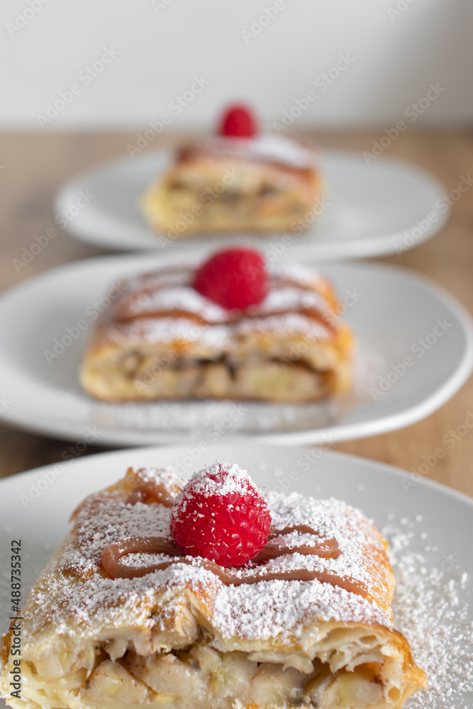 Apple quiche with powdered sugar and garnished with raspberries Apple quiche with powdered sugar and garnished with raspberries