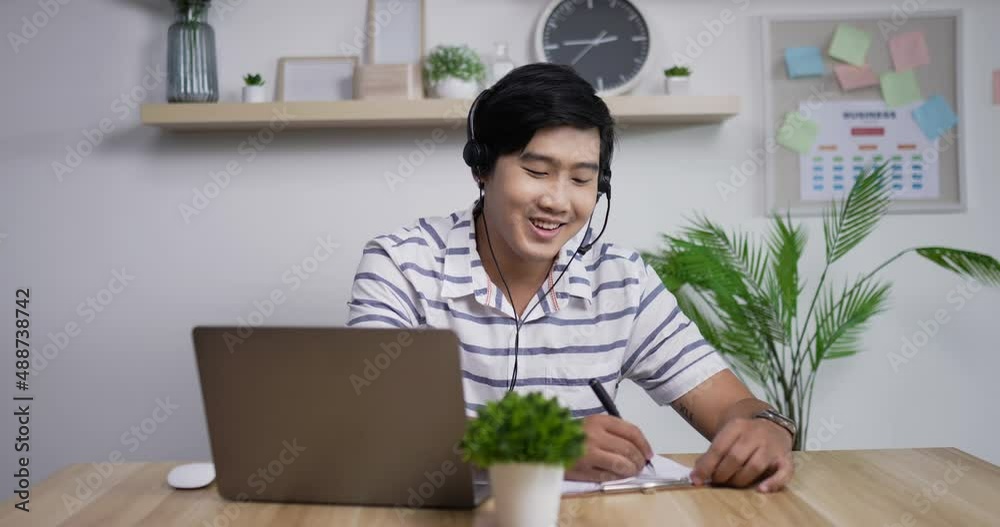 Portrait of Young Asian customer service support agent telemarketer man wearing headset looking at laptop make business conference internet video call. Portrait of Young Asian customer service support agent telemarketer man wearing headset looking at laptop make business conference internet video call.