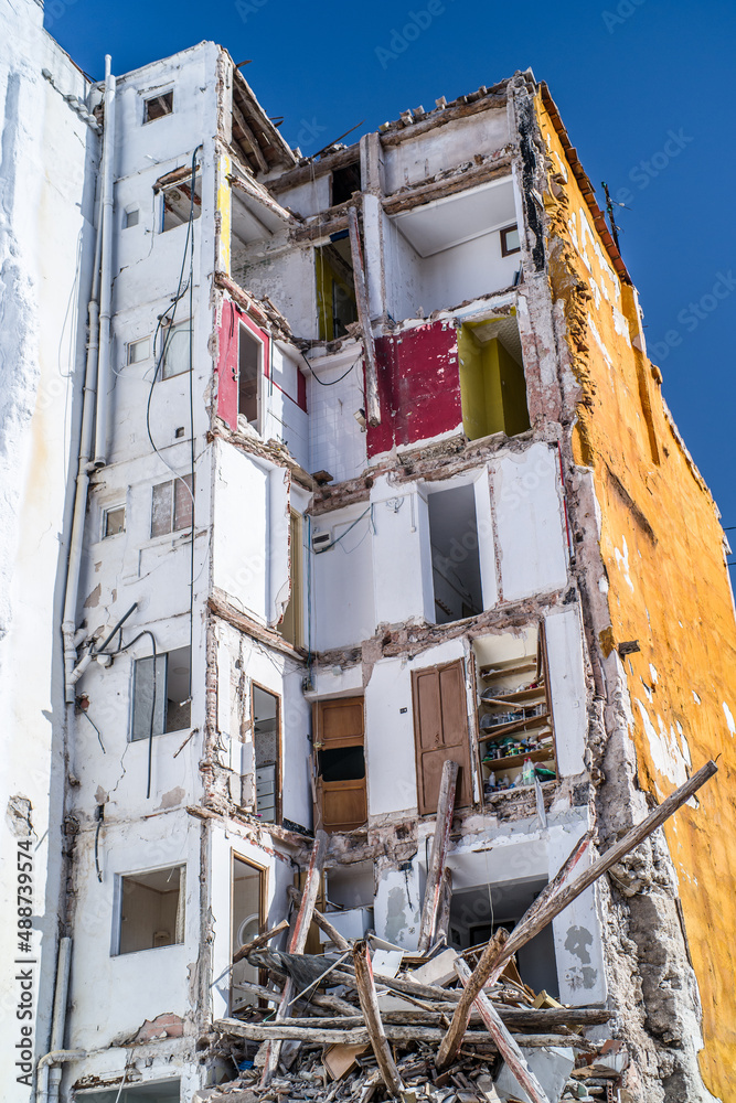 building in ruin with a collapsed wall and visible damaged apartments