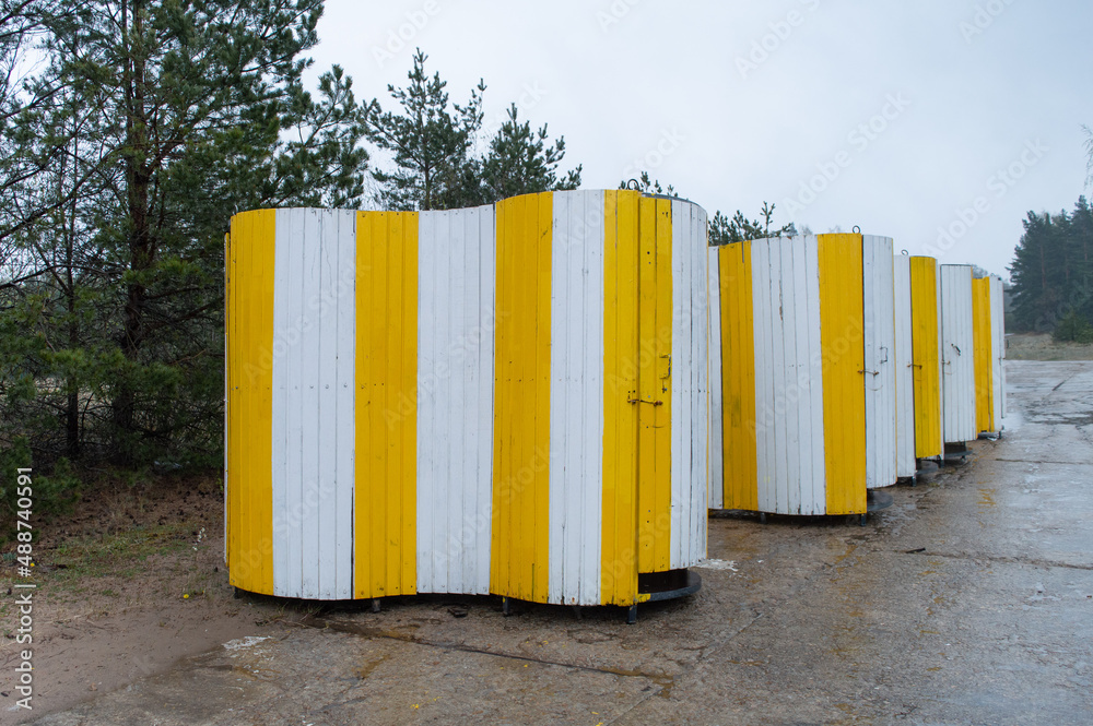 Naklejka premium Strand toilets. Yellow movable strand toilets in a row