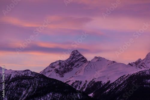 Winter scenery while sunrise in the European Alps, Graubuenden, Switzerland, with snow-covered mountains, clouds, and sky