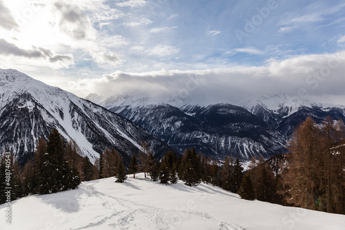 Winter scenery in the European Alps  Graubuenden  Switzerland  with snow-covered mountains  clouds  and sky