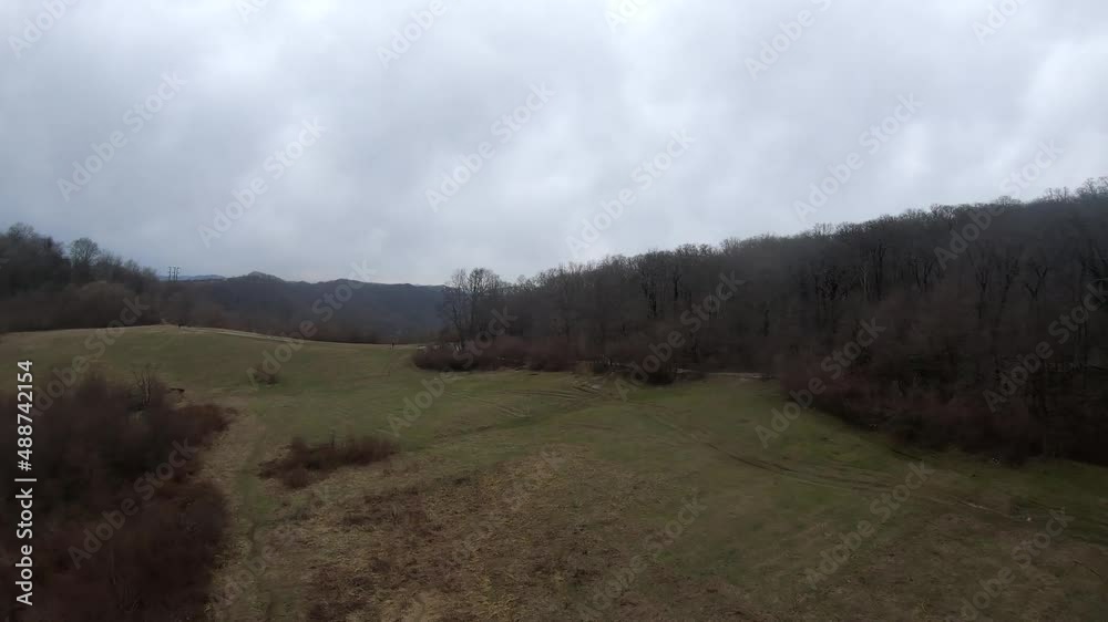 fpv quadcopter flight in the mountains, Sochi, grass on a glade, gray green forest, beautiful high rocks, huge stones, blue sky and sea on the horizon fpv quadcopter flight in the mountains, Sochi, grass on a glade, gray green forest, beautiful high rocks, huge stones, blue sky and sea on the horizon