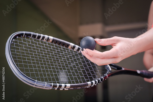 Image of a woman's hand with a squash racket. Sports concept © andy_gin