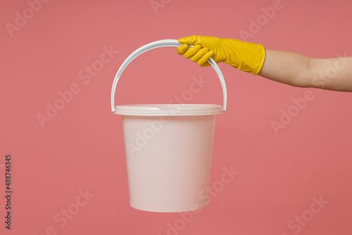 Foto a hand in a rubber glove holds an empty plastic bucket
