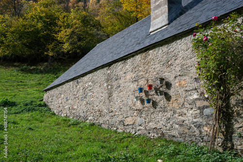 Installation de pots sur le mur d'une grange de montagne.
