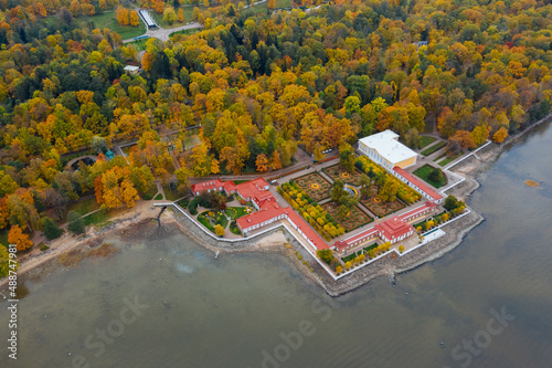 Aerial view of the lower park in Peterhof, the Monplaisir Palace, the promenade along the Gulf of Finland, a garden of autumn trees and a fountain in the center photo