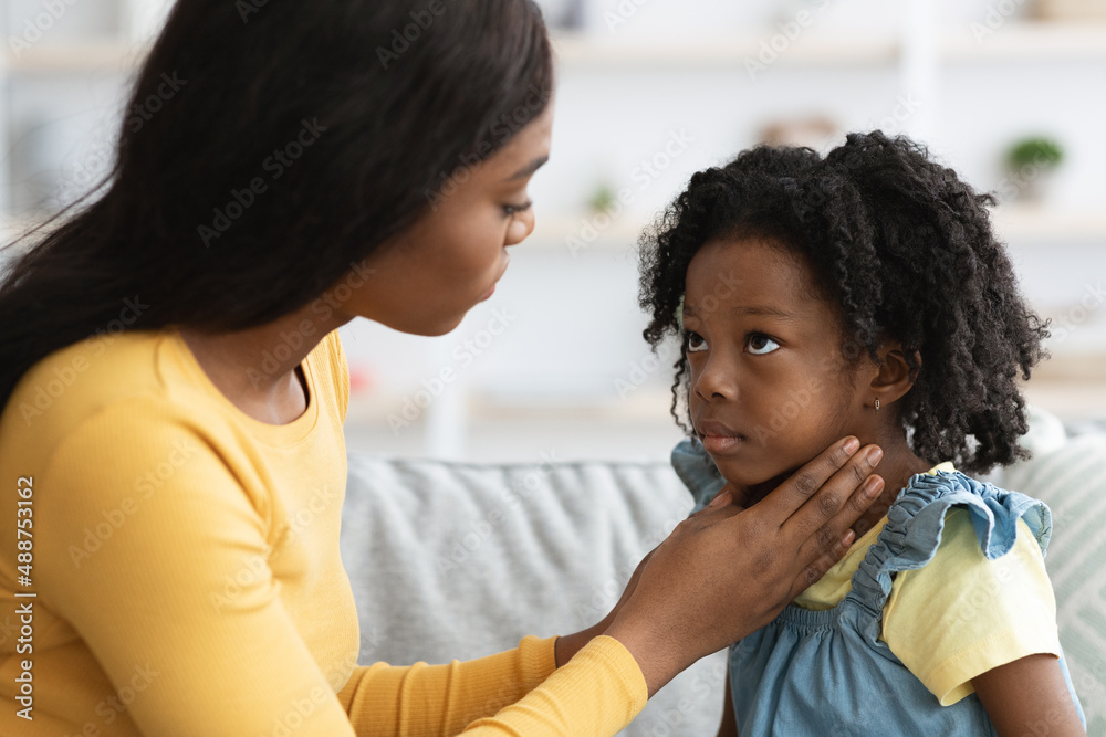 Black mom taking care of her sick child suffering from sore throat Black mom taking care of her sick child suffering from sore throat