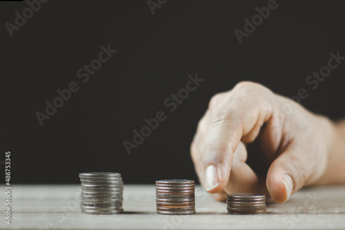 Male hand putting money coin stack for the future growing business.