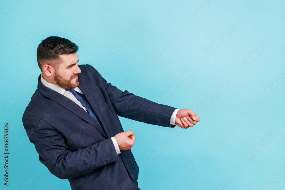 Portrait of strong ambitious businessman in suit pretending to pull invisible rope, concept of hard working, striving and efforts to achievements. Indoor studio shot isolated on blue background. Portrait of strong ambitious businessman in suit pretending to pull invisible rope, concept of hard working, striving and efforts to achievements. Indoor studio shot isolated on blue background.