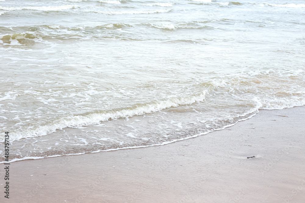 Small seaside waves near shoreline in sand. Small seaside waves near shoreline in sand.