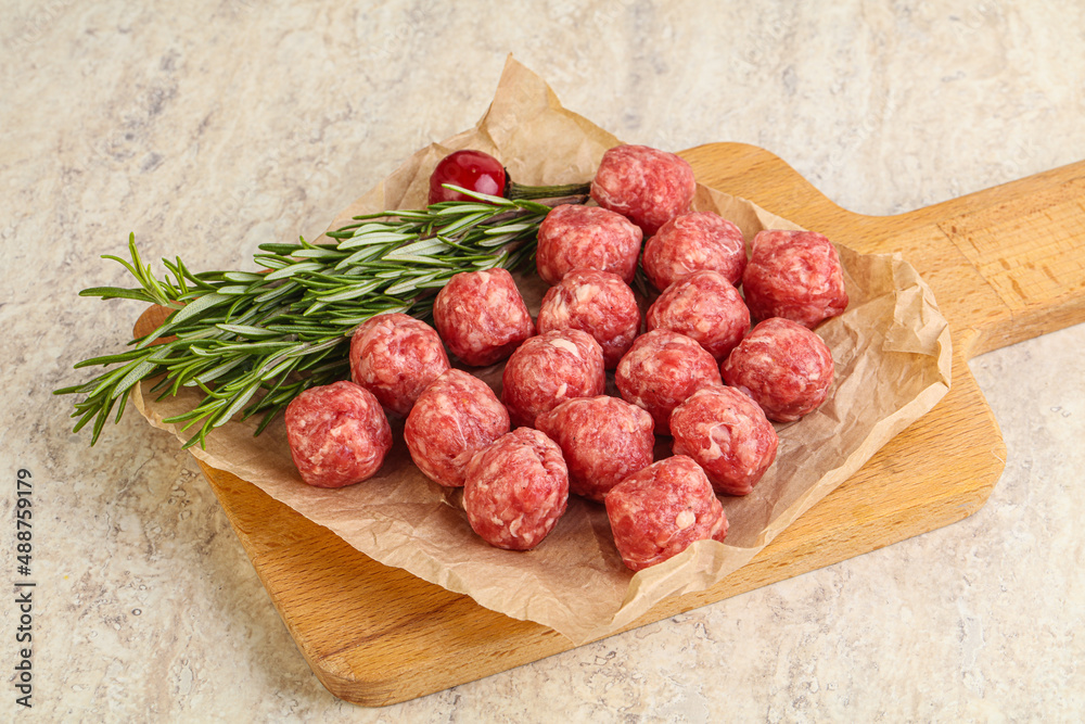 Raw uncooked beef meatballs served rosemary Raw uncooked beef meatballs served rosemary